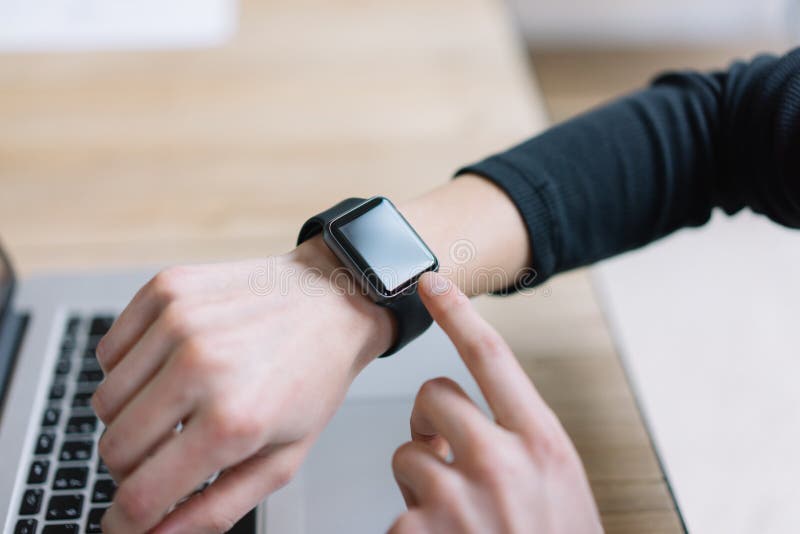Fotokvinna som arbetar den moderna vinden, genom att använda den smarta klockan för generisk design Kvinnlign räcker smartwatch f arkivfoto Fotokvinna som arbetar den moderna vinden, genom att använda den smarta klockan för generisk design Kvinnlign räcker smartwatch f arkivfoto