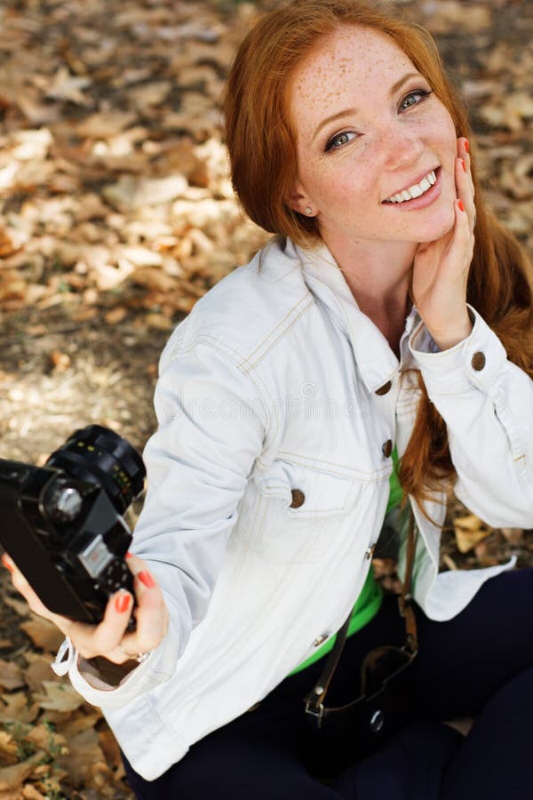 Fotógrafo agradable de la muchacha que toma el selfe en parque del otoño foto de archivo libre de regalías Fotógrafo agradable de la muchacha que toma el selfe en parque del otoño foto de archivo libre de regalías
