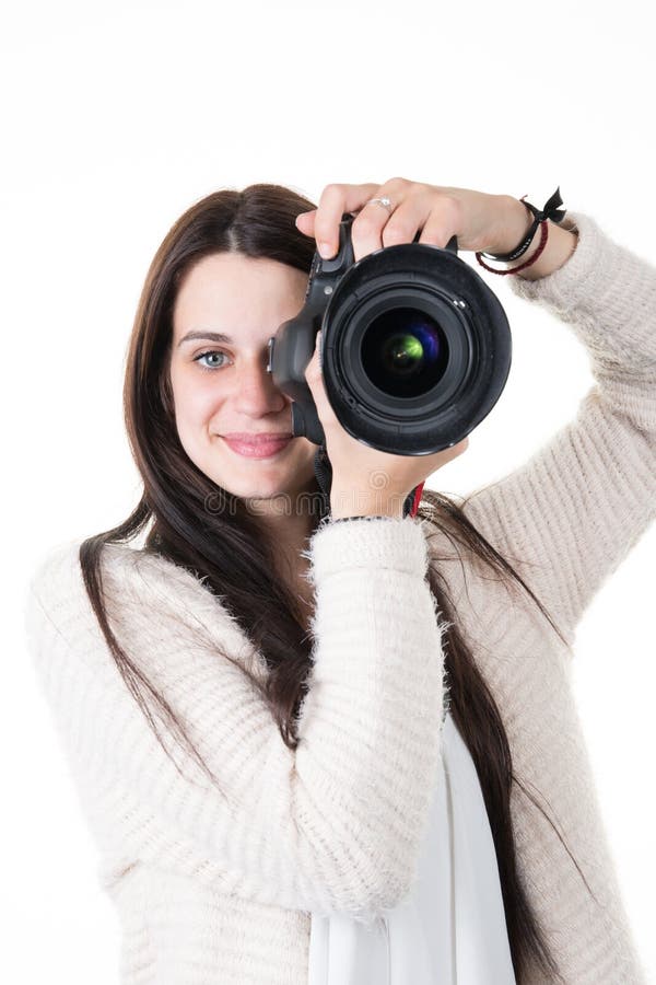 Fotógrafo bonito do instrutor da jovem mulher que toma imagens no fundo branco imagem de stock royalty free Fotógrafo bonito do instrutor da jovem mulher que toma imagens no fundo branco imagem de stock royalty free
