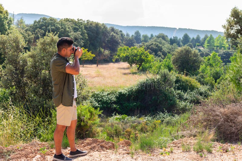 Fotógrafo pronto para tomar uma fotografia no campo foto de stock Fotógrafo pronto para tomar uma fotografia no campo foto de stock
