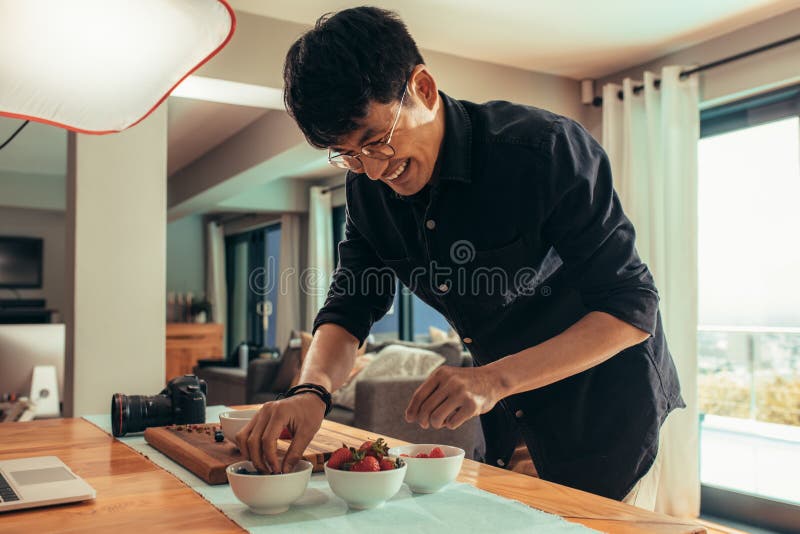 Fotógrafo sonriente de la comida que diseña la comida para el lanzamiento fotografía de archivo Fotógrafo sonriente de la comida que diseña la comida para el lanzamiento fotografía de archivo
