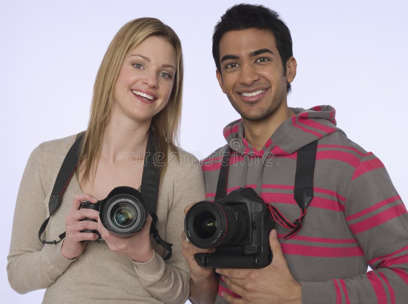 Portrait of young women and men with digital cameras in studio. Portrait of young women and men with digital cameras in studio