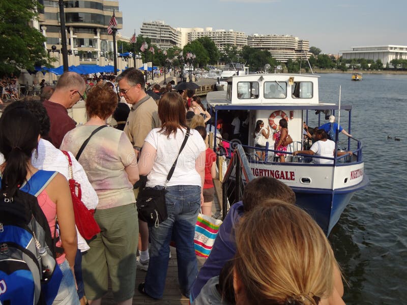 Photo of crowd of people boarding a tour boat on the potomac river in georgetown of washington dc on 7/2/11. This is a busy weekend leading up to july 4th. Photo of crowd of people boarding a tour boat on the potomac river in georgetown of washington dc on 7/2/11. This is a busy weekend leading up to july 4th.