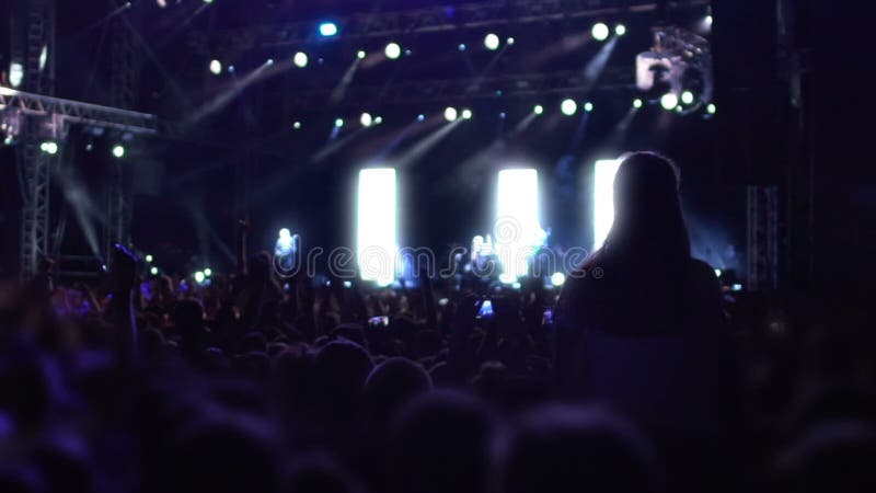Foule enthousiaste sautant et dansant pendant la représentation de groupe de rock, vie nocturne active banque de vidéos