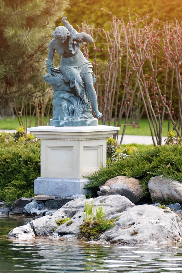 Fountain With Statue Of A Woman In The Park Near The Lake Stock Image