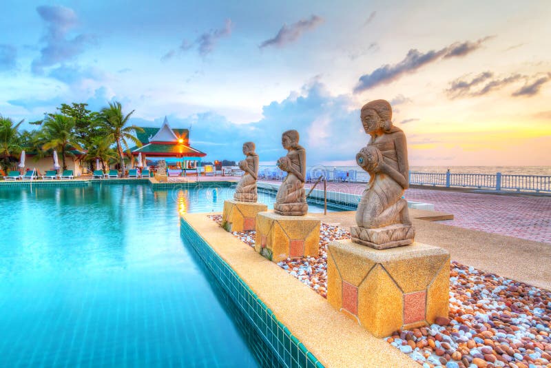 Fountain statues at the tropical swimming pool at sunset