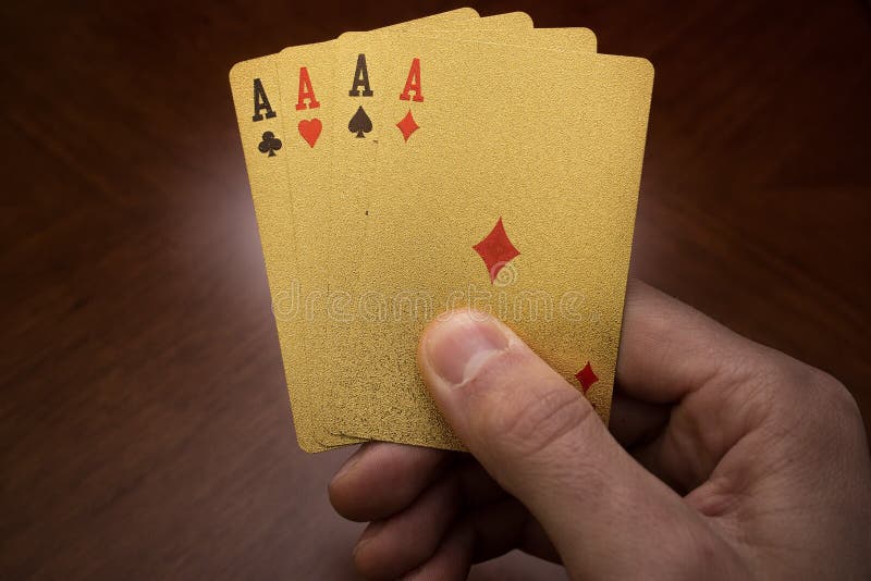 Four aces in hand, golden card in hands, four playing cards in the right hand royalty free stock image Four aces in hand, golden card in hands, four playing cards in the right hand royalty free stock image