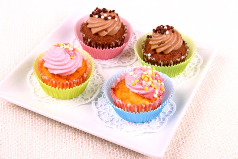 Four appetizing cupcakes on white plate. Top view stock images Four appetizing cupcakes on white plate. Top view stock images