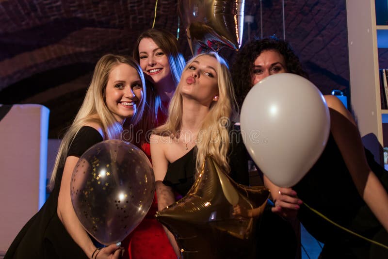 Four beautiful young Caucasian women holding balloons having night out together in trendy bar royalty free stock image Four beautiful young Caucasian women holding balloons having night out together in trendy bar royalty free stock image