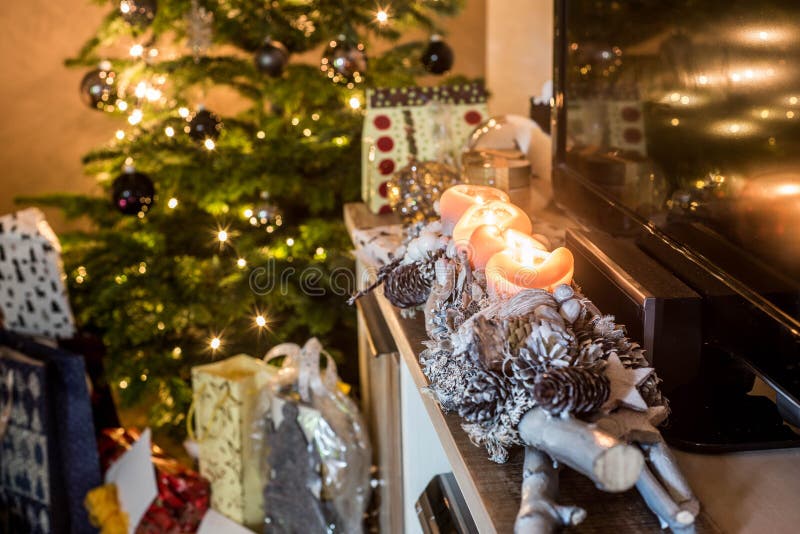 Four burning advent candles, beautiful decorated setup lights in Background christmas tree with gifts stock image Four burning advent candles, beautiful decorated setup lights in Background christmas tree with gifts stock image