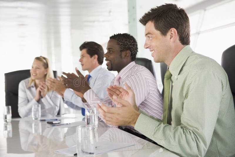 Four businesspeople applauding at boadroom meeting. Boardroom table clapping stock images, royalty-free photos and pictures
