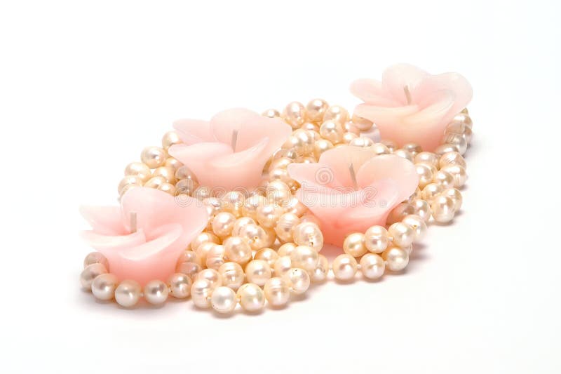 Four Candles in the Form of a Flower and a Pearl Necklace Stock Photo