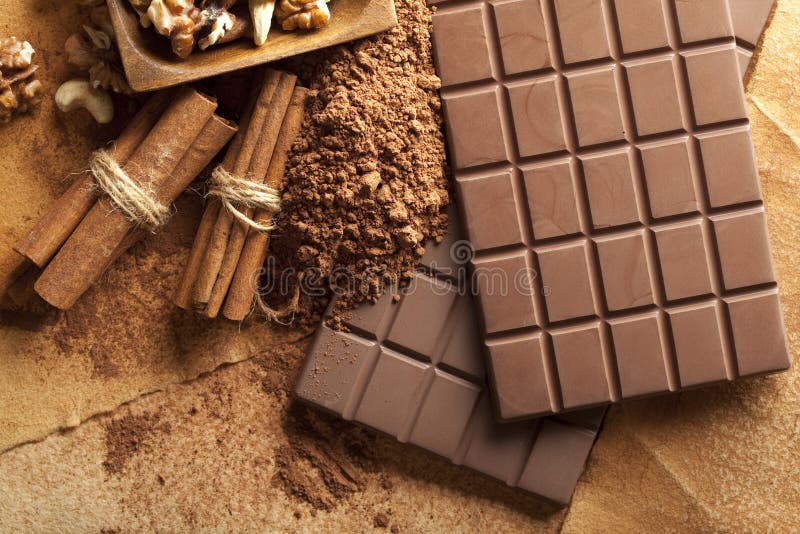 Four Chocolate Bars, Cinnamon Sticks, Cocoa and Mixed Nuts Stock Photo