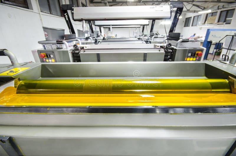 Four color print press machine, yellow color ink roller royalty free stock photos