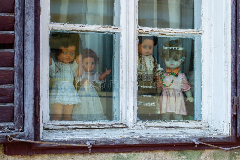 Four creepy dolls dressed in white and with traditional Romanian clothes, displayed in a window, while looking at the people stock image Four creepy dolls dressed in white and with traditional Romanian clothes, displayed in a window, while looking at the people stock image