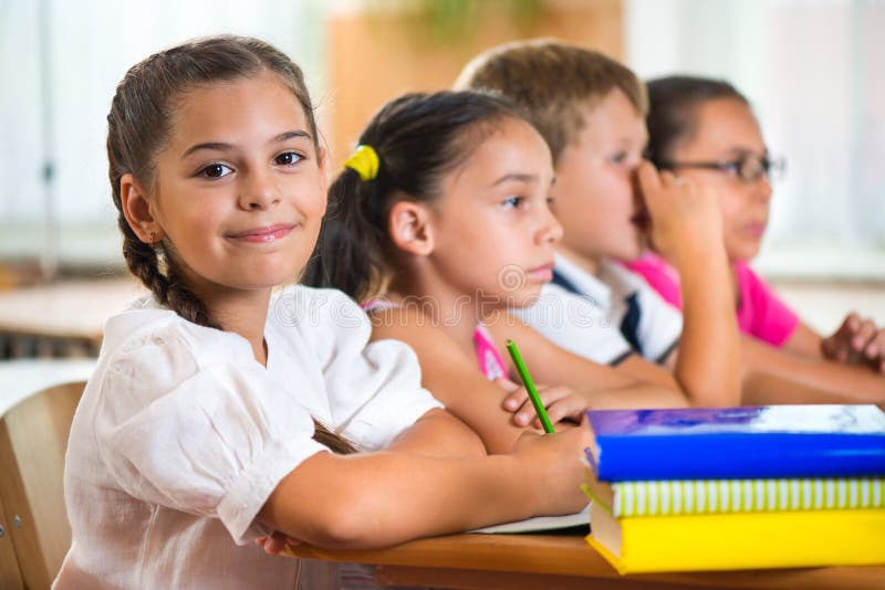 Four diligent pupils studying at classroom stock photos