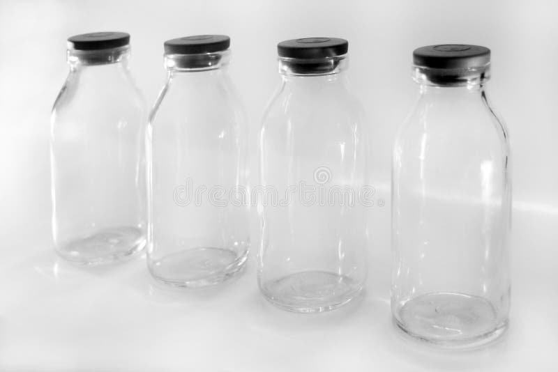 Four Glass Bottles Filled With Coins With Label Paper Of Medicine