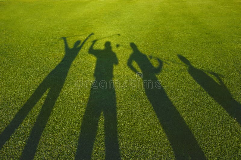 Four golfers silhouette on grass