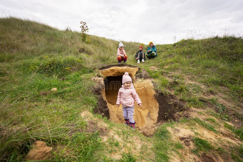 Four Kids Explore Limestone Stone Cave at Mountain Stock Photo Image