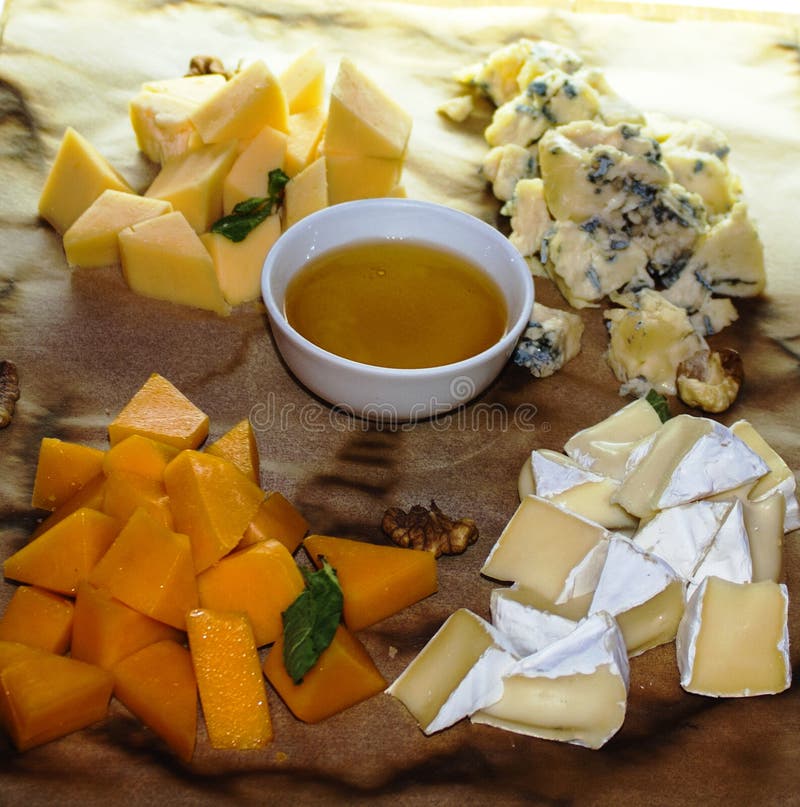 Four kinds of cheese with honey and bread stock photo