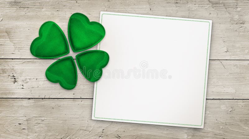 Green four leaf clover and greeting card on wood, copy space