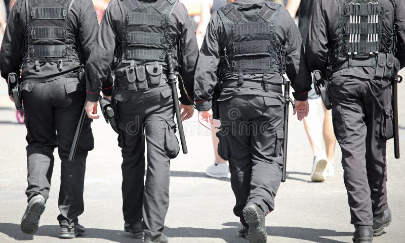 Cuatro hombres a prueba de balas chaleco patrullando calles de la ciudad.