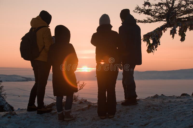 Four people meet the sunset on lake Baikal, Russia, Siberia