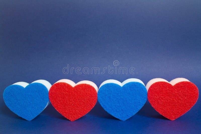 Red Heart Shape Dishwash Sponge between Two Blue Heart Shape Dishwasher