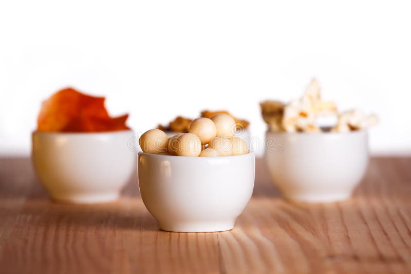 Four Small Bowls of Snacks on Natural Wooden Table. Stock Image Image