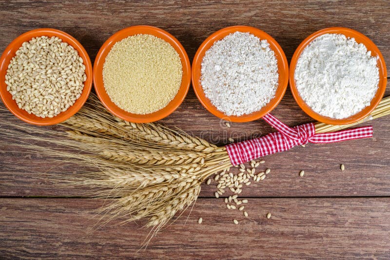 Four small bowls with whole wheat, couscous, whole wheat flour, all purpose flour and sheaf of wheat ears stock photo Four small bowls with whole wheat, couscous, whole wheat flour, all purpose flour and sheaf of wheat ears stock photo