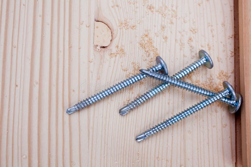 Four steel screws on wood plank