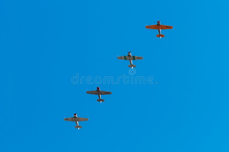 EDEN PRAIRIE, MN - JULY 16, 2016: Four AT6 Texan airplanes fly in formation against clear sky at air show. The AT-6 Texan was primarily used as trainer aircraft during and after World War II. EDEN PRAIRIE, MN - JULY 16, 2016: Four AT6 Texan airplanes fly in formation against clear sky at air show. The AT-6 Texan was primarily used as trainer aircraft during and after World War II.