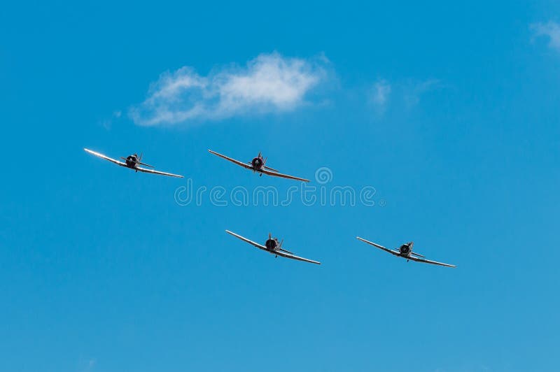 EDEN PRAIRIE, MN - JULY 16, 2016: Four AT6 Texan airplanes line up straight on at air show. The AT-6 Texan was primarily used as trainer aircraft during and after World War II. EDEN PRAIRIE, MN - JULY 16, 2016: Four AT6 Texan airplanes line up straight on at air show. The AT-6 Texan was primarily used as trainer aircraft during and after World War II.