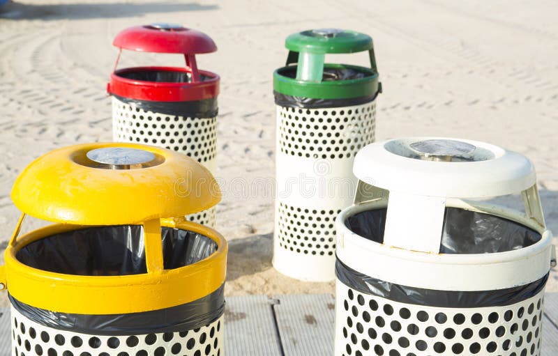 Four trash cans on the beach sunny day