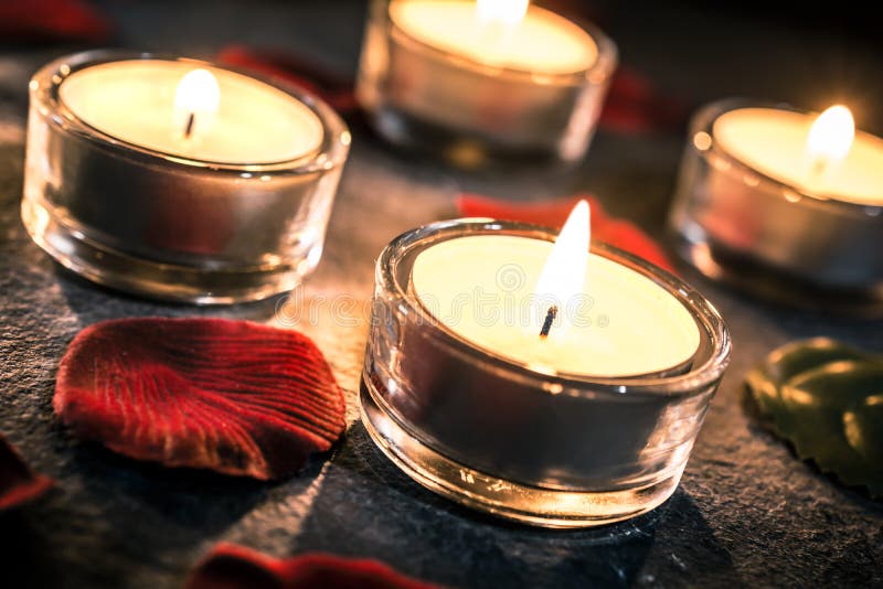 Four Valentine Candlelights on Slate with Rose Petals and Leafs Stock