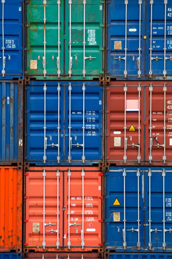 Four vertical rows of shipping containers that are different colors in the Port of Zeebrugge, Belgium