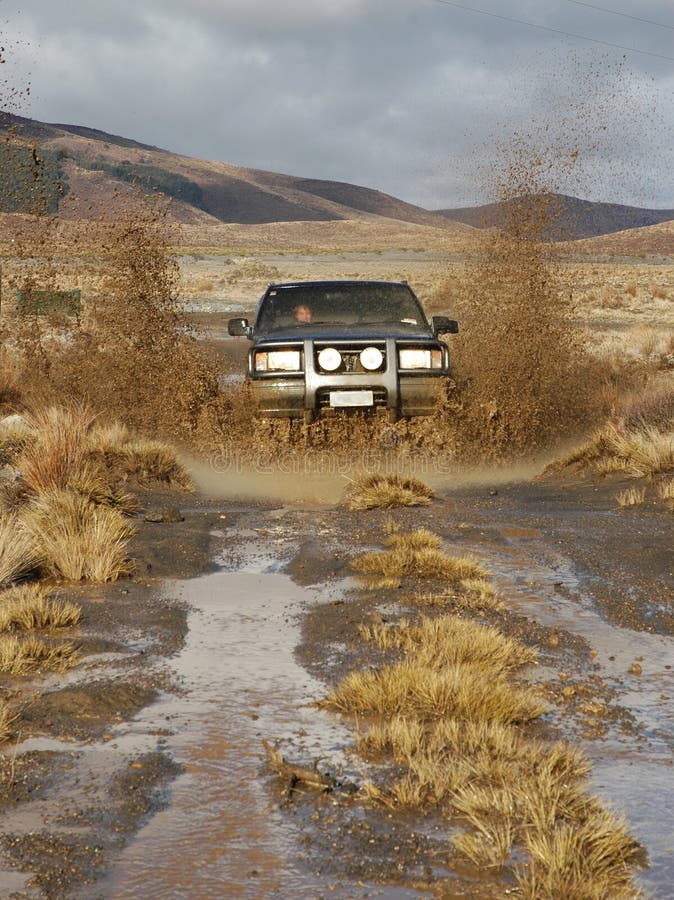 Four wheel drive splashing through mud puddle. Four wheel drive splashing through mud puddle