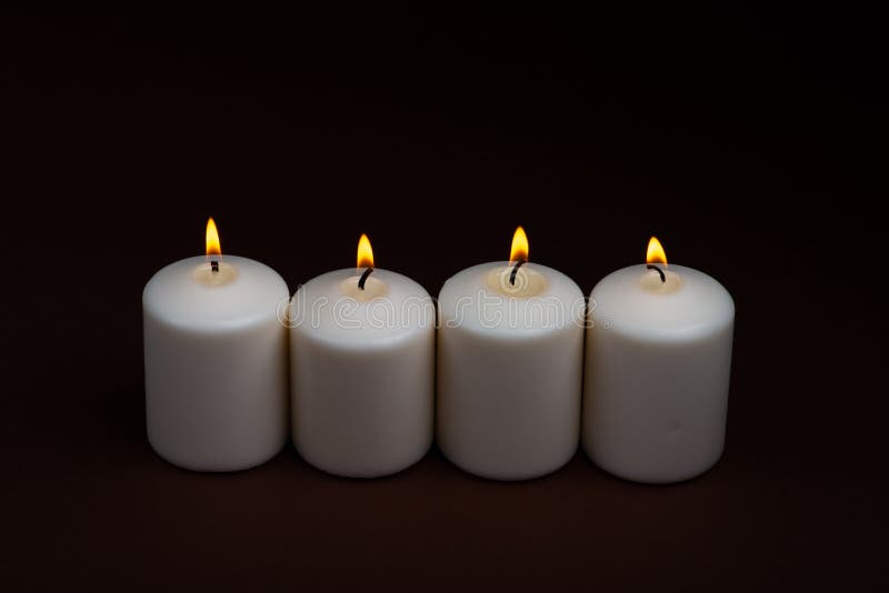 Four White candles flame burning on dark Background with copy space for