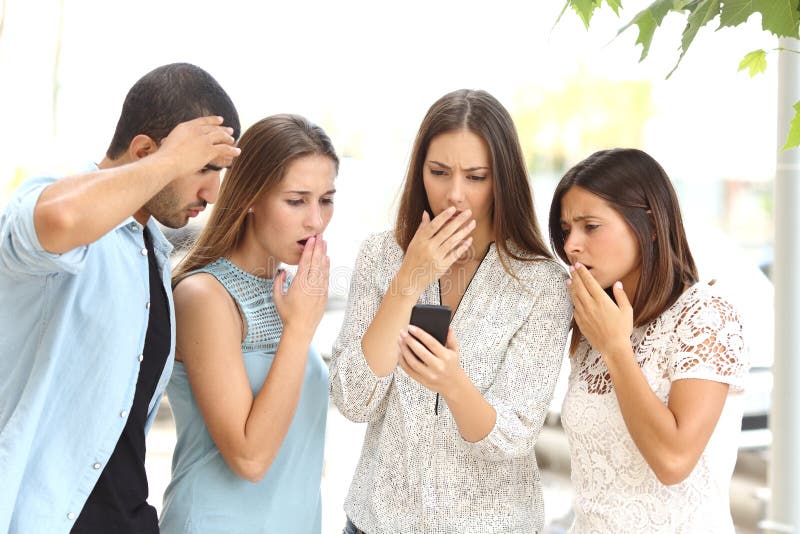 Four worried friends watching smart phone stock photo Four worried friends watching smart phone stock photo