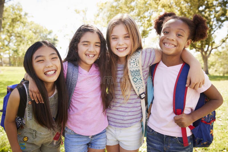 Four young smiling schoolgirls on a school trip