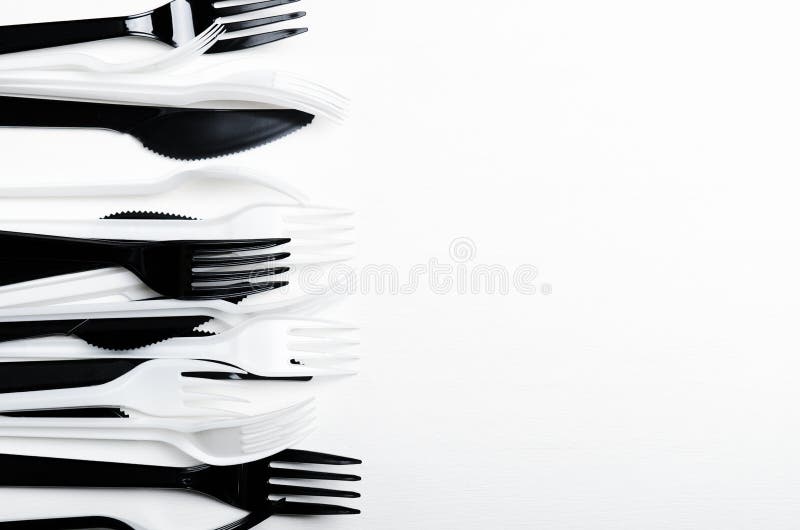 Fourchettes en plastique et couteaux jetables blancs et noirs sur un fond blanc Plats en plastique L'espace de copie, vue supérie images libres de droits Fourchettes en plastique et couteaux jetables blancs et noirs sur un fond blanc Plats en plastique L'espace de copie, vue supérie images libres de droits