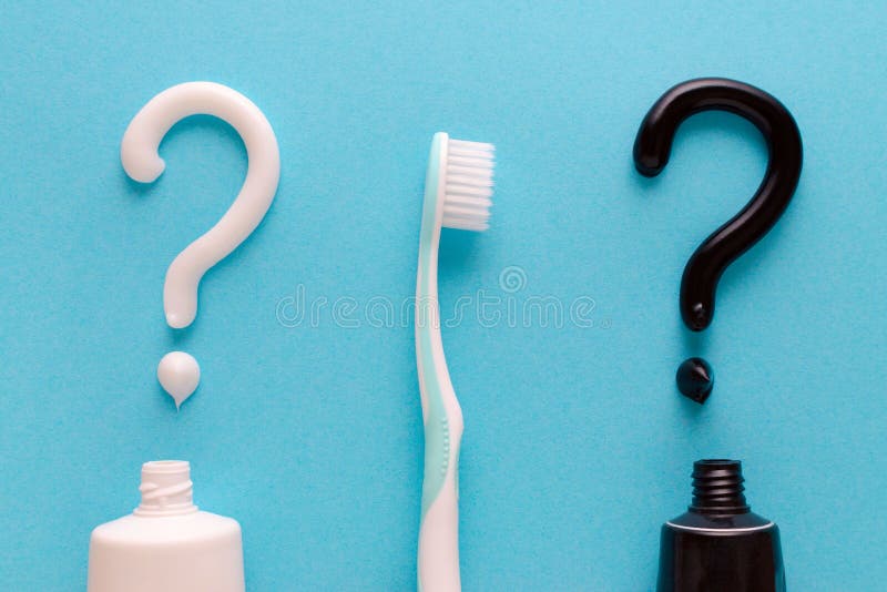 Frage von der weißen und schwarzen Zahnpasta, Zähne interessieren sich Konzept, Zahnbürste auf blauem Hintergrund stockbild