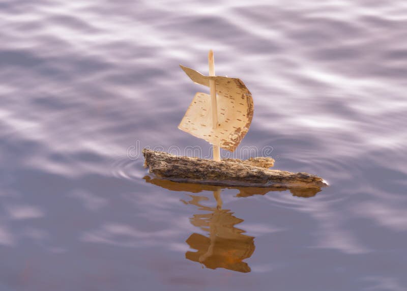 Frágil pequeno navegación un barco hecho de una pieza de madera abedul corteza, navegación sobre el espumoso agua cómo el sol es un configuración.