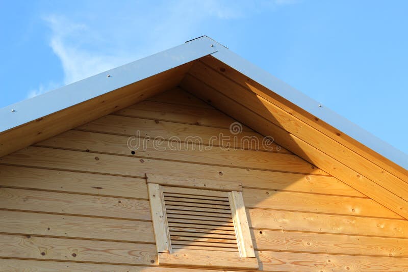 Fragment of just installed wooden roof eaves with ventilation grille. House improvement concept