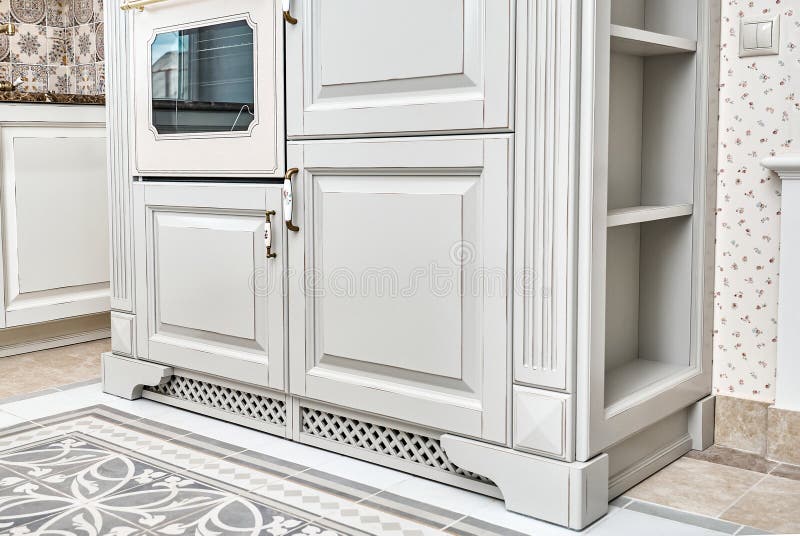 Fragment of kitchen cabinet with built-in oven and microwave in country style