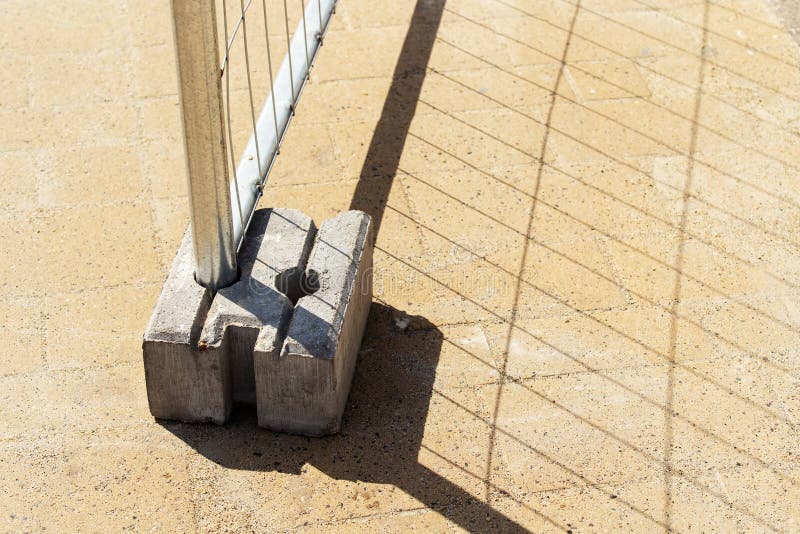 A Fragment of a Metal Fence with a Concrete Support. Closeup Stock