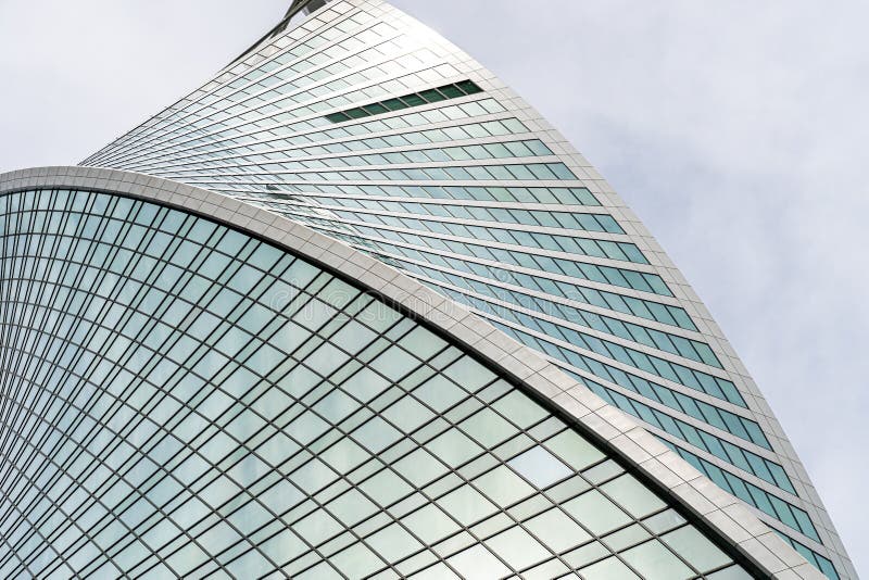 Fragment of a modern office building. Abstract geometric background. Part of a skyscraper with glass windows. royalty free stock photography