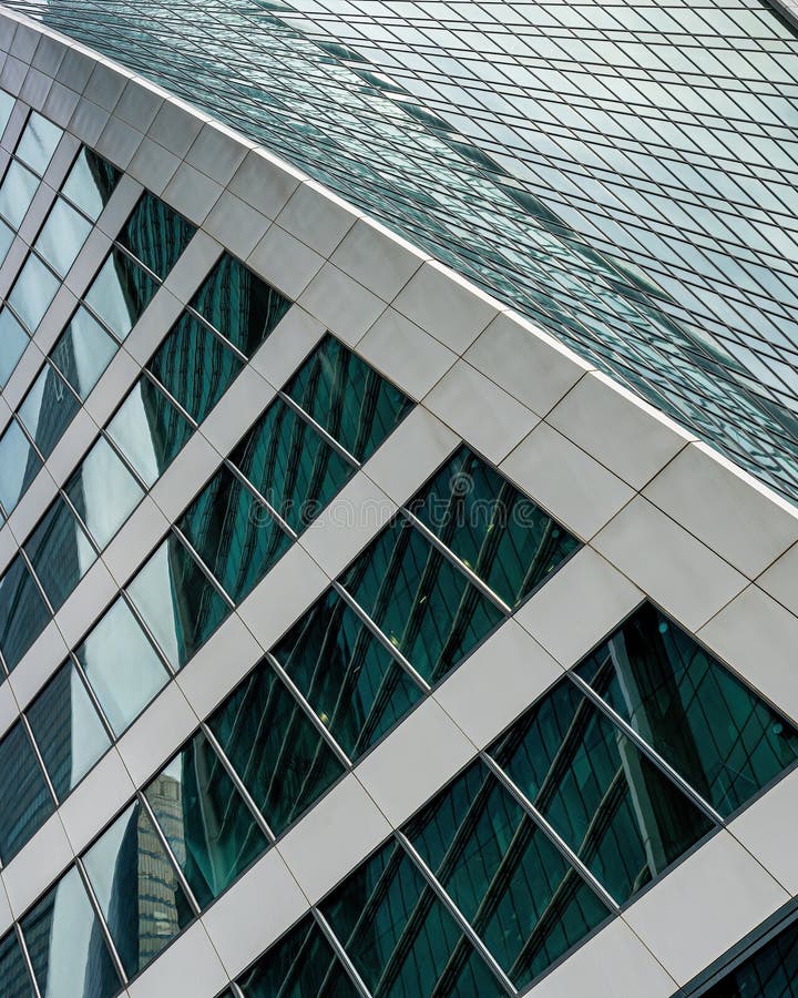 Fragment of a modern office building. Abstract geometric background. Part of a skyscraper with glass windows. royalty free stock photos
