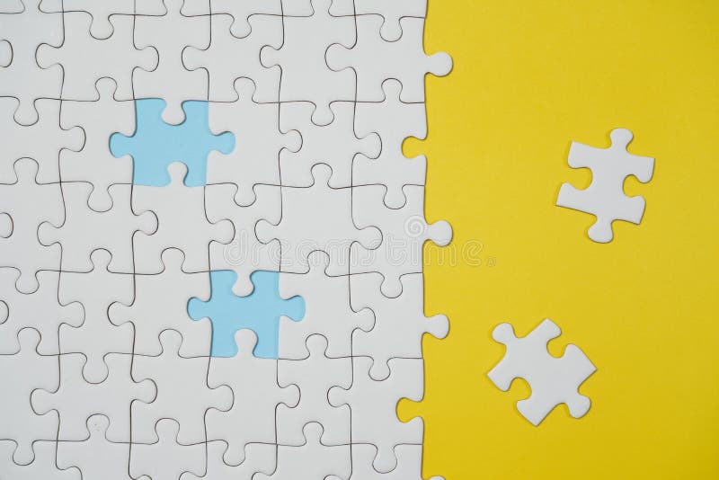 Fragment van een gevouwen witte puzzel en een stapel van uncombed raadselelementen tegen de achtergrond van een gele oppervlakte royalty-vrije stock foto's Fragment van een gevouwen witte puzzel en een stapel van uncombed raadselelementen tegen de achtergrond van een gele oppervlakte royalty-vrije stock foto's