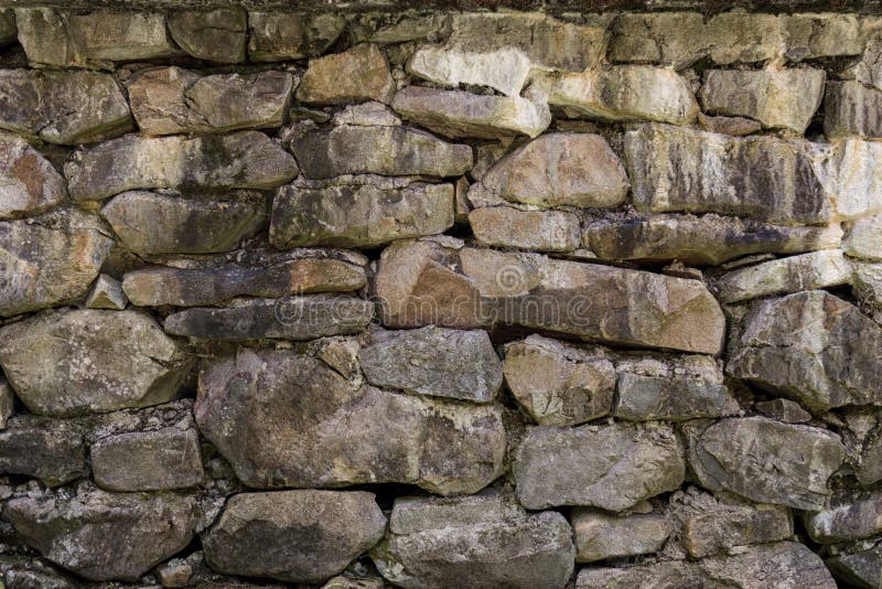 Fragmentet av den gamla stenväggen som göras av olikt form och format, vaggar arkivfoto Fragmentet av den gamla stenväggen som göras av olikt form och format, vaggar arkivfoto